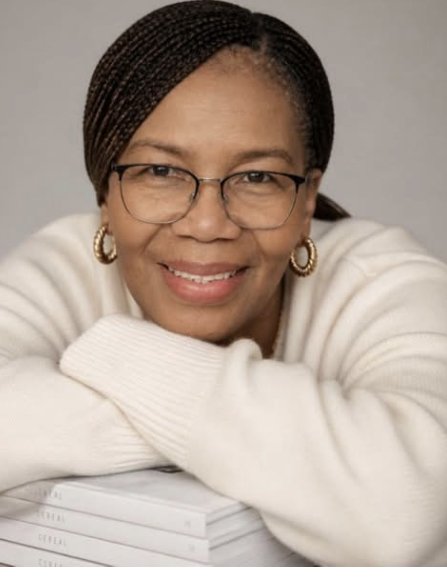 Lina Martinez smiling, resting on a stack of her books
